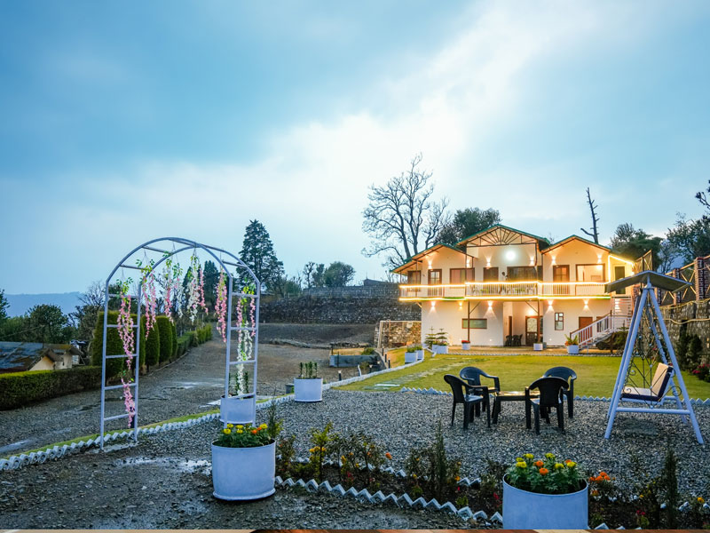 4bhk bedroom with double bed and seating area at Monal Meadows villa in Naukuchiatal
